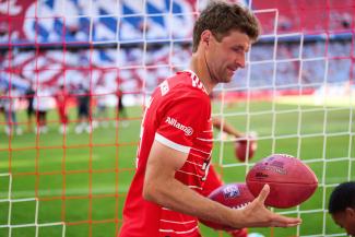 Thomas Müller in der Allianz Arena mit einem Football in der Hand