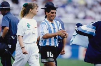 Diego Maradona wird bei der WM 1994 von einer Frau im weißen "Medical"-Anzug zur Doping-Kontrolle begleitet