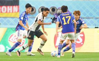 Jamal Musiala gegen einige japanische Spieler während des Spiels bei der WM 2022