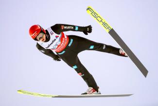 Skispringer Karl Geiger in der Luft beim Weltcup in Engelberg