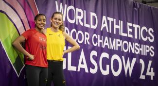 Die deutschen Leichtathletinnen Mikaelle Assani und Christina Honsel vor dem Logo der Hallen-WM in Glasgow